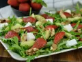 Pyszna sałatka z truskawkami, awokado, orzechami i serem feta na rukoli. Idealna na letni obiad.