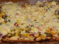 Pyszna pizza na grubym cieście z warzywami i roztopionym serem.