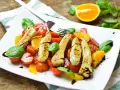 Pyszna sałatka z pomarańczą, grillowanym kurczakiem, pomidorkami i bazylią, polana sosem balsamicznym.