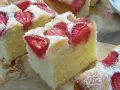 Puszyste ciasto na maślance z kawałkami truskawek, posypane cukrem pudrem. Idealne na letnie popołudnie.