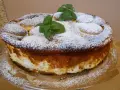 Pyszny sernik na biszkoptach, oprószony cukrem pudrem i ozdobiony listkami mięty. Idealny na deser.