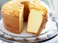 Puszyste ciasto z białek, z wyciętym kawałkiem, prezentuje swoją delikatną strukturę i złocisty kolor. Idealne na każdą okazję.