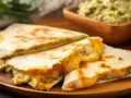 Pyszne quesadillas z roztopionym serem i guacamole. Idealna, fajna szybka kolacja na drewnianej desce.