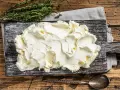 Kremowe mascarpone na desce, gotowe do użycia. Czy mascarpone można mrozić? Tak, ale po rozmrożeniu może zmienić konsystencję.