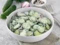 Mizeria przepis: świeże ogórki pokrojone w plasterki, wymieszane z kremowym sosem jogurtowym i koperkiem. Idealna na letni obiad.