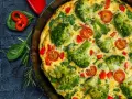 Pyszny omlet z warzywami: brokuły, pomidorki koktajlowe i papryka w złocistym jajku. Idealny na zdrowe śniadanie.