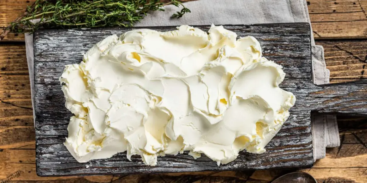 Kremowe mascarpone na desce, gotowe do użycia. Czy mascarpone można mrozić? Tak, ale po rozmrożeniu może zmienić konsystencję.