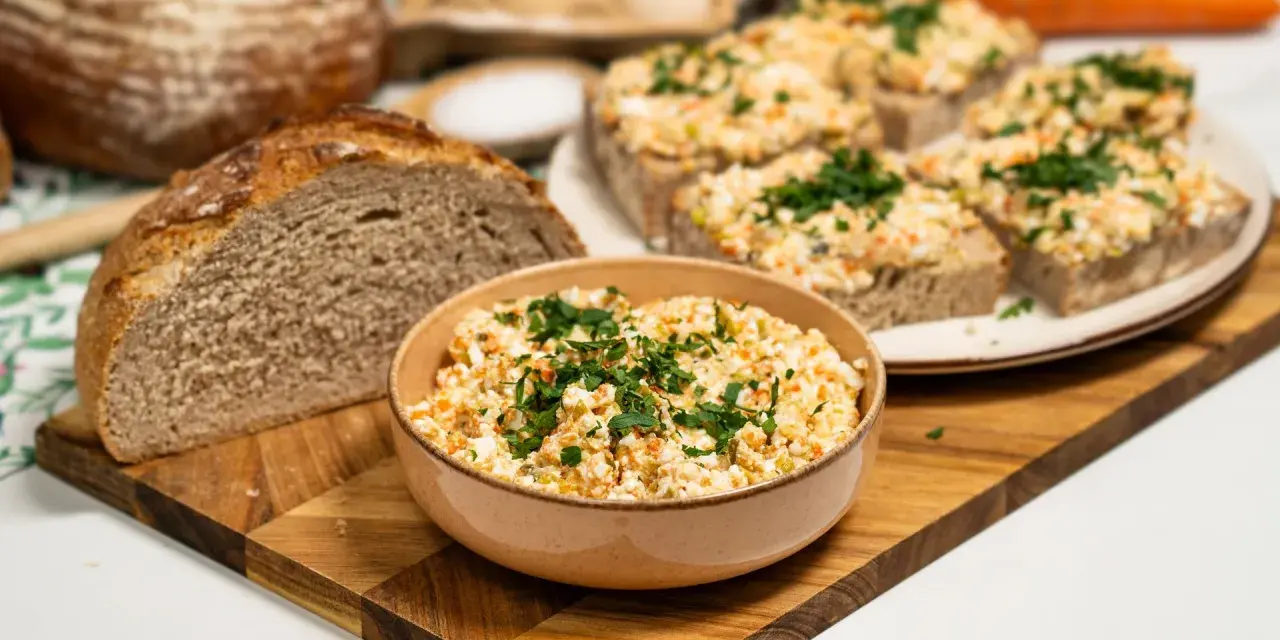 Pyszna pasta na kanapki z jajek, warzyw i ziół, podana z chlebem. Idealna na śniadanie lub przekąskę.