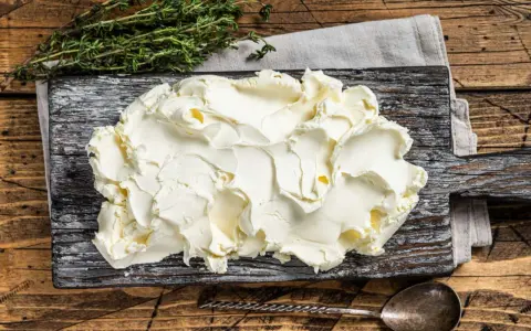 Kremowe mascarpone na desce, gotowe do użycia. Czy mascarpone można mrozić? Tak, ale po rozmrożeniu może zmienić konsystencję.