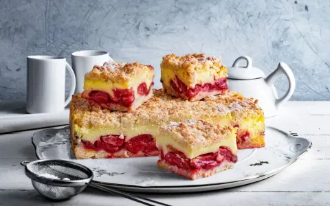 Pyszna tarta z truskawkami i budyniem, posypana kruszonką, czeka na spróbowanie. Idealna na deser!