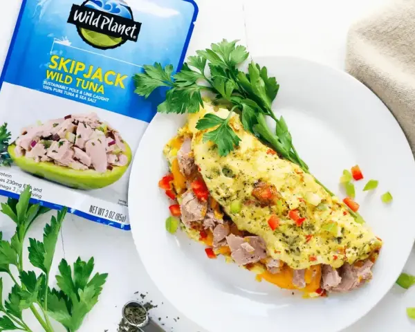 Pyszny omlet z tuńczykiem, papryką i ziołami, obok opakowanie tuńczyka Wild Planet.