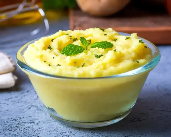 Puszyste puree ziemniaczane, idealne do nauki jak zrobić puree. Udekorowane listkami mięty i posypane natką.