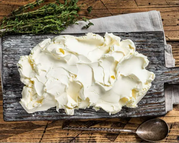 Kremowe mascarpone na desce, gotowe do użycia. Czy mascarpone można mrozić? Tak, ale po rozmrożeniu może zmienić konsystencję.
