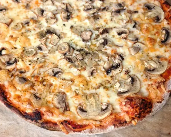 Pyszna pizza z pieczarkami i ciągnącym serem. Idealna na wspólne spotkanie, bo ile piec pizze, tyle radości!