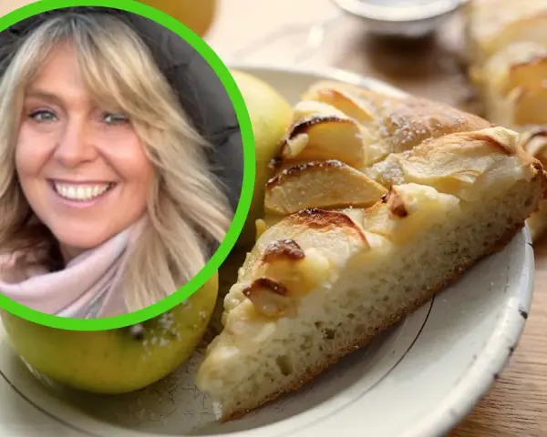 Uśmiechnięta blondynka na tle pysznego, domowego ciasta drożdżowego z jabłkami.