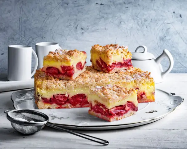Pyszna tarta z truskawkami i budyniem, posypana kruszonką, czeka na spróbowanie. Idealna na deser!