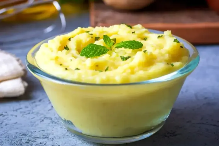 Puszyste puree ziemniaczane, idealne do nauki jak zrobić puree. Udekorowane listkami mięty i posypane natką.
