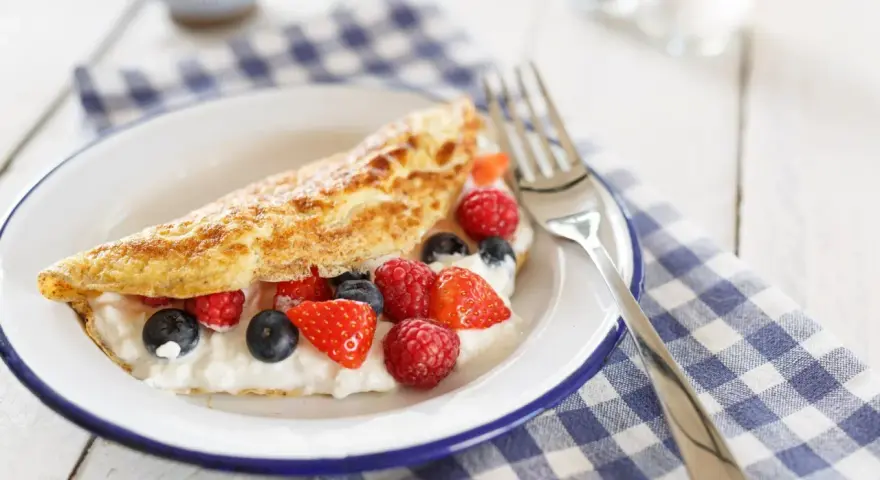 Słodki omlet z serkiem i owocami leśnymi, idealny na śniadanie. Ten przepis na omlet na słodko zachwyci każdego.