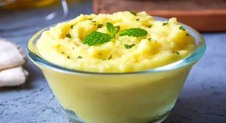 Puszyste puree ziemniaczane, idealne do nauki jak zrobić puree. Udekorowane listkami mięty i posypane natką.