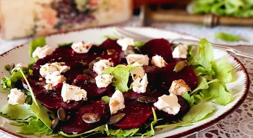 Pyszne carpaccio z buraka z serem feta i pestkami dyni na talerzu.