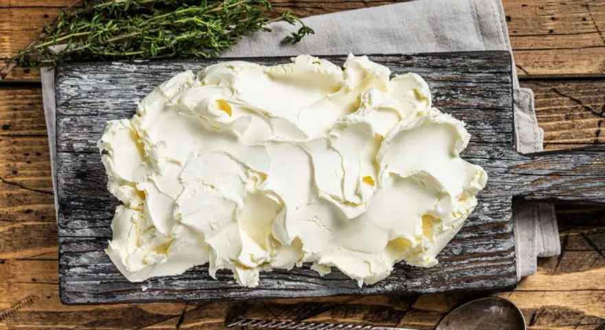 Kremowe mascarpone na desce, gotowe do użycia. Czy mascarpone można mrozić? Tak, ale po rozmrożeniu może zmienić konsystencję.