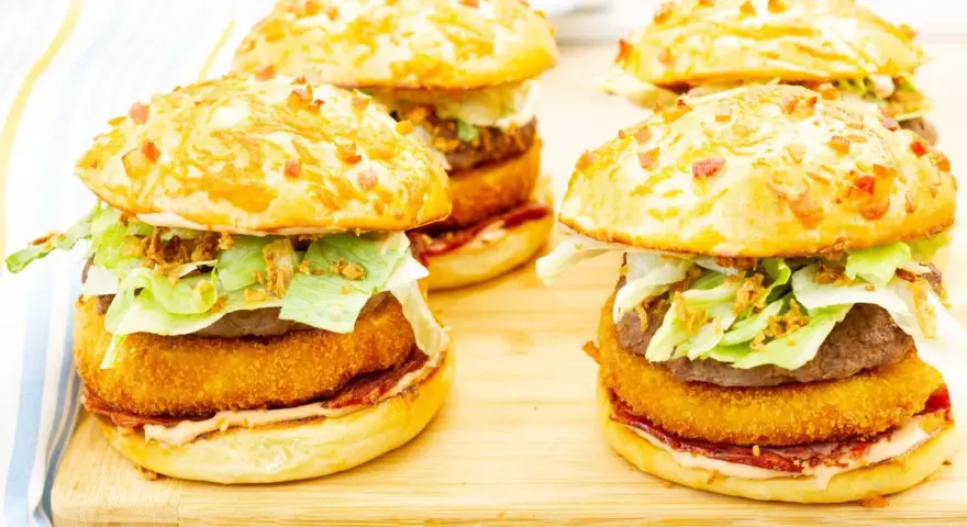 Pyszny burger drwala przepis: soczysty kotlet, chrupiąca panierka, świeża sałata i chrupiąca cebulka w bułce z bekonem.
