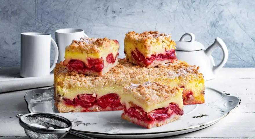 Pyszna tarta z truskawkami i budyniem, posypana kruszonką, czeka na spróbowanie. Idealna na deser!