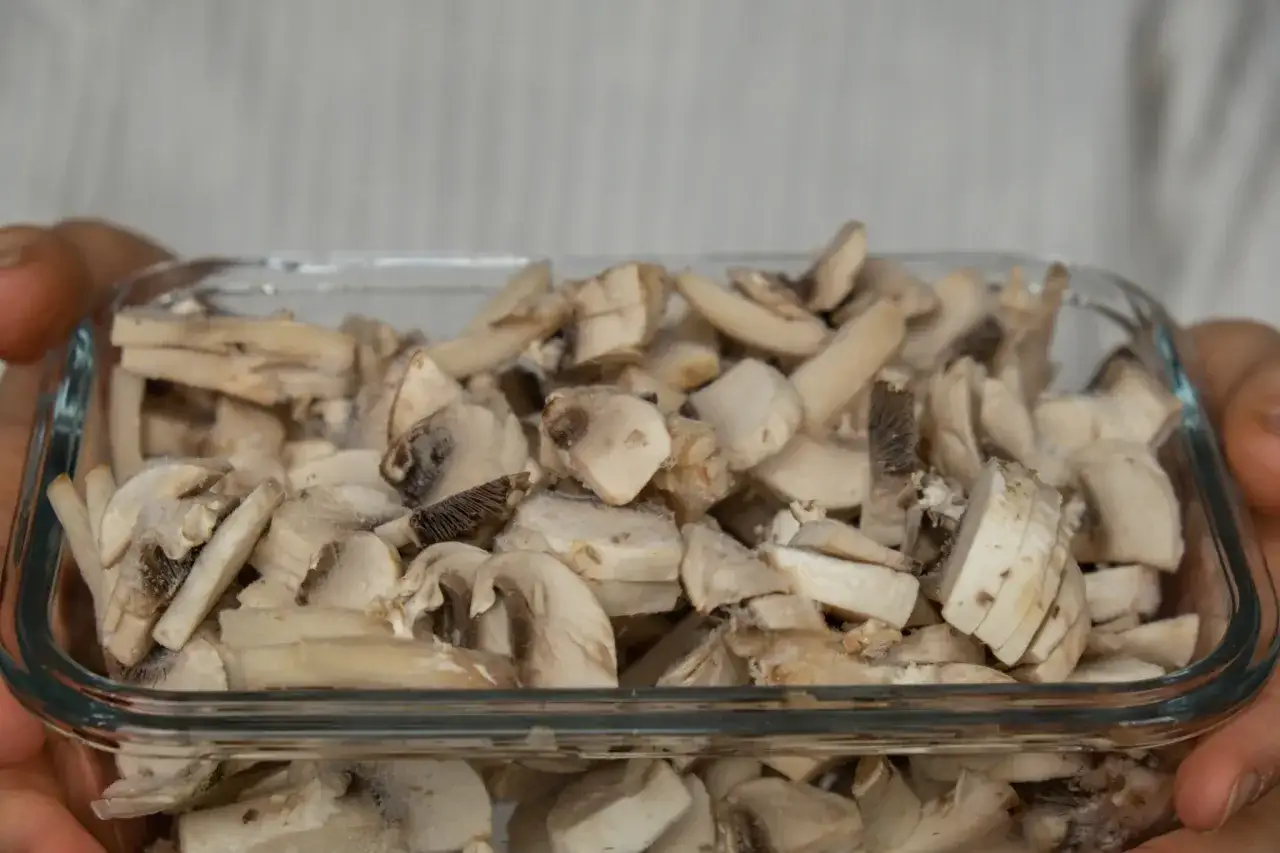 Pokrojone pieczarki w szklanym pojemniku, gotowe do mrożenia. Tak, pieczarki można mrozić, zachowując ich smak i aromat.