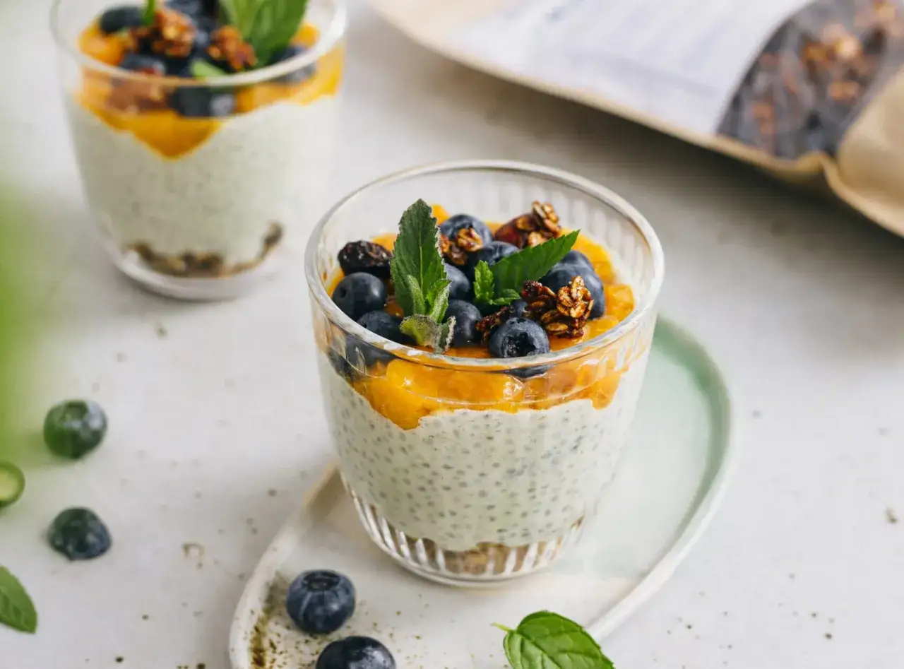 Pyszny pudding chia z musem mango, jagodami i granolą. Idealny przepis na zdrowe śniadanie.