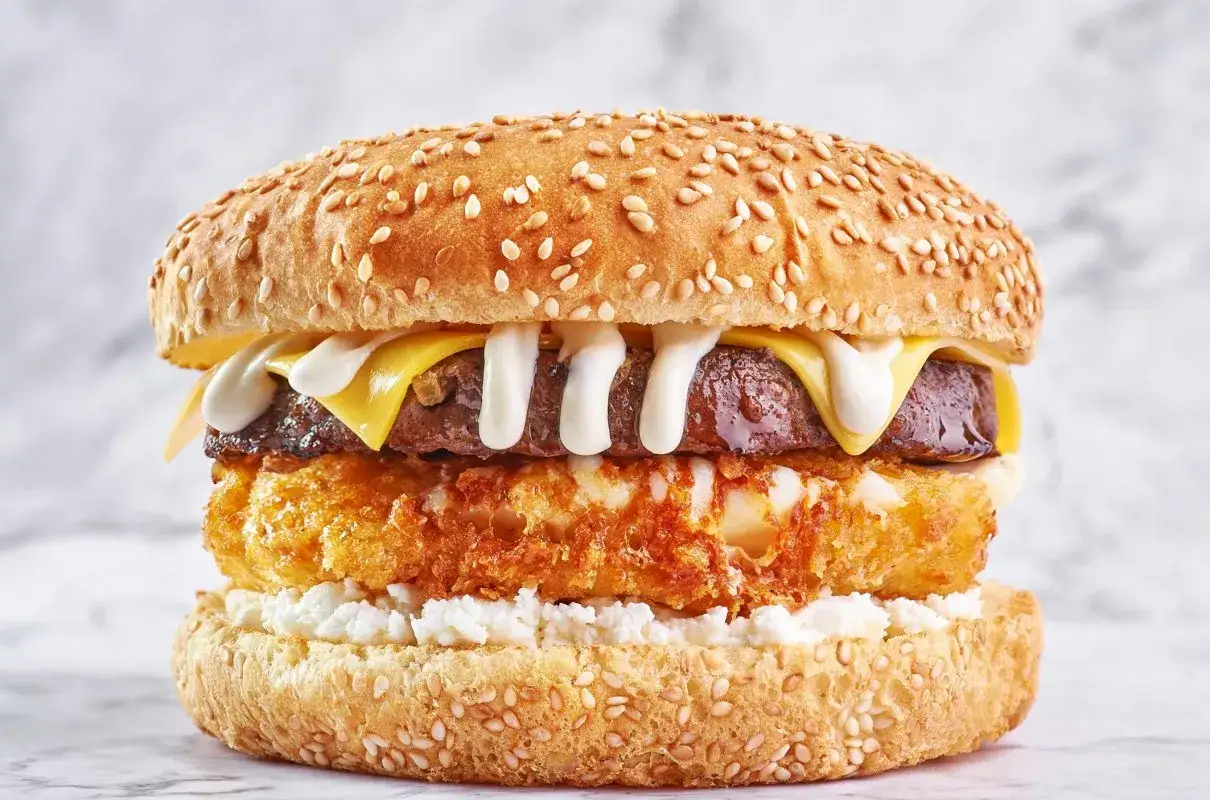 Pyszny burger drwala przepis: soczysty kotlet, chrupiąca panierka, ser i biały sos na sezamowej bułce.