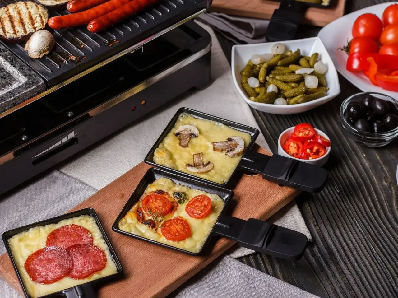 Raclette z pieczarkami, pomidorami i salami. Idealny ser do raclette roztopiony na patelniach.