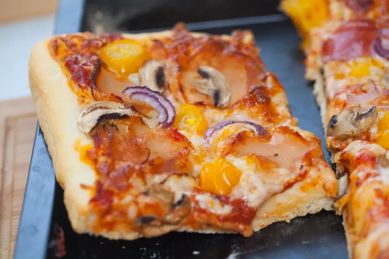 Domowa pizza na blachę z pieczarkami, cebulą i pomidorkami. Idealna na rodzinny obiad.