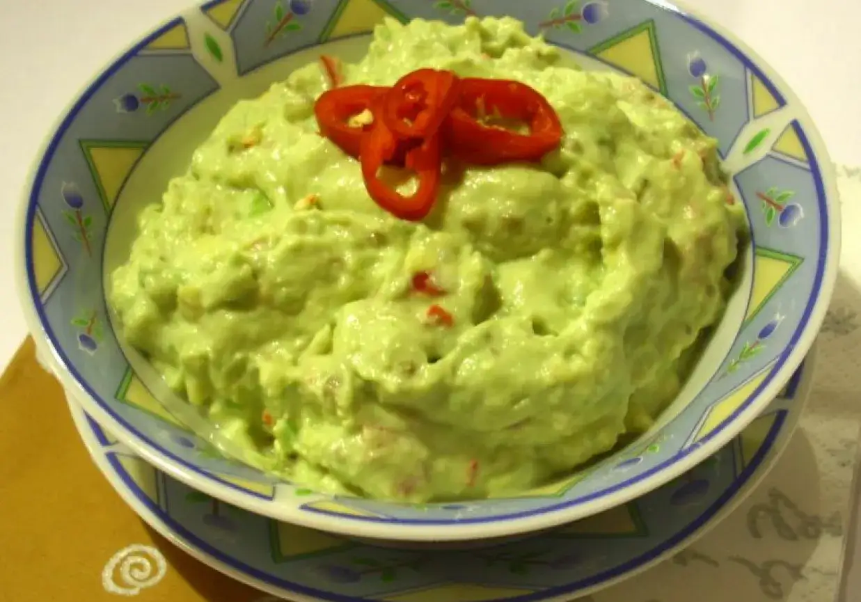 Pyszne guacamole w misce, ozdobione plasterkami chili. Idealne z nachos lub jako dodatek do tacos. Z czym jeść guacamole? Z tym, co lubisz!